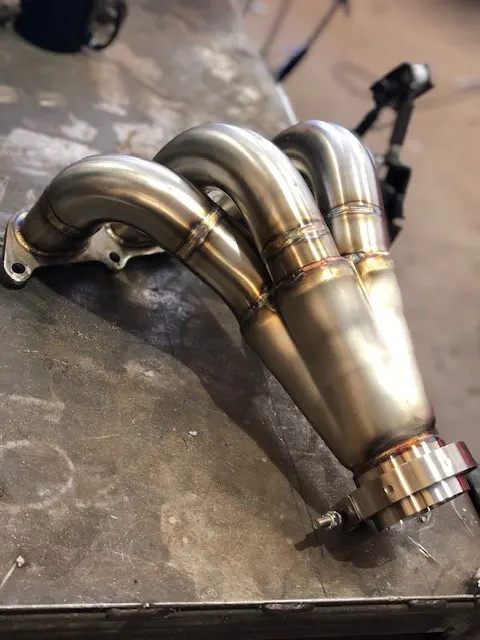Close-up of a TIG weld on stainless, heat tint running from straw to peacock blue